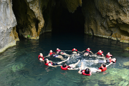 Swimming in the crystal clear water of E cave (Trung Tre cave)