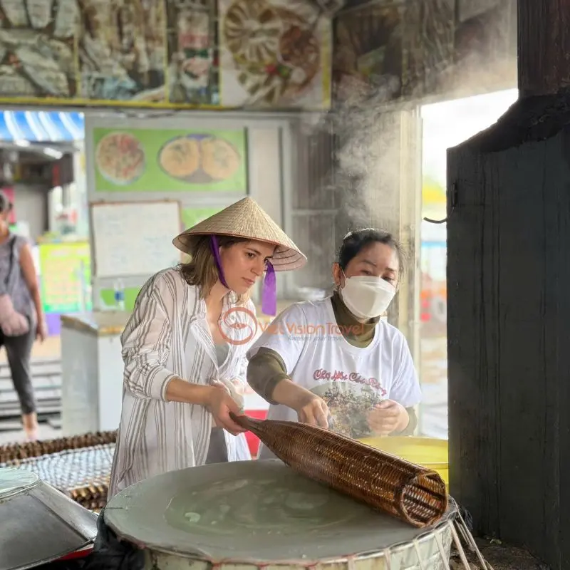 Local Vietnam tour companies guide travelers to join cooking classes like making rice paper.