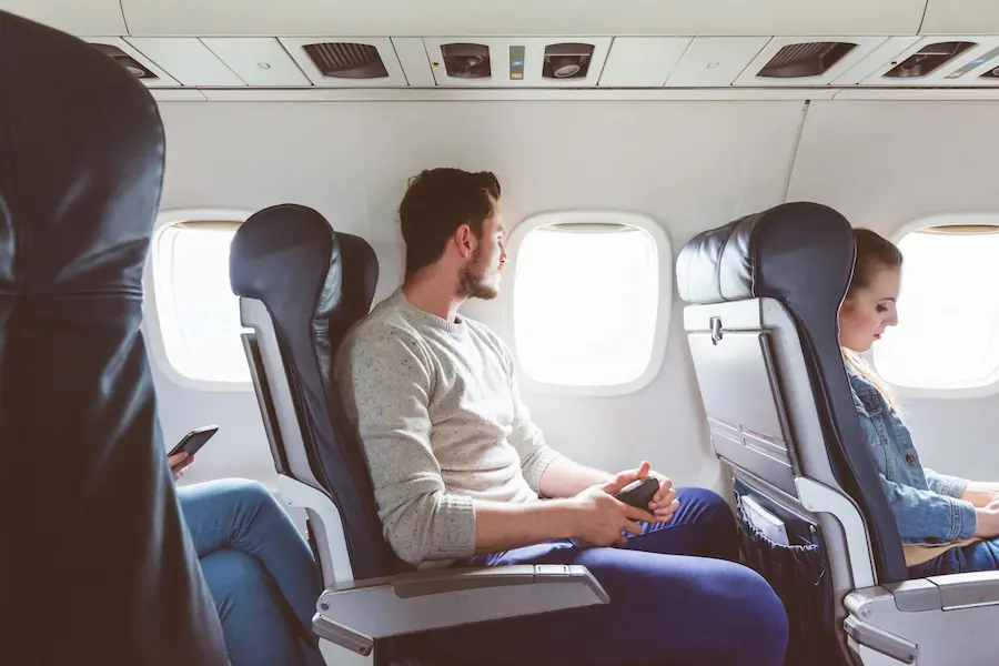 passengers seated inside an airplane cabin during a flight