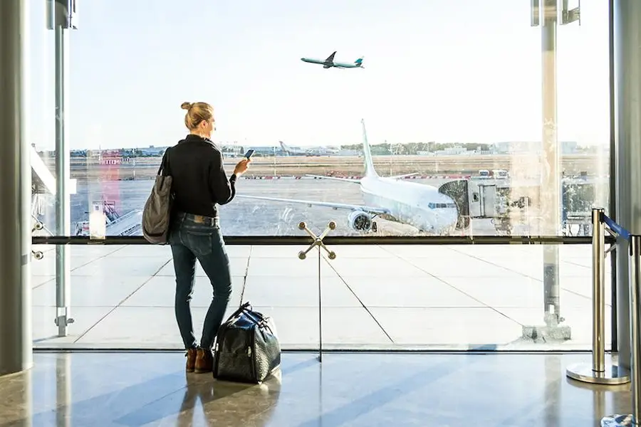 traveler checking updated flight details at an airport terminal
